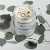Jar of eucalyptus candle with eucalyptus leaves on a white background